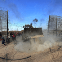PALESTINIANS BREAKING DOWN THE BORDER FENCE WITH ISRAEL FROM KHAN YUNIS IN THE SOUTHERN GAZA STRIP ON OCTOBER 7, 2023. (PHOTO: STRINGER/APA IMAGES)